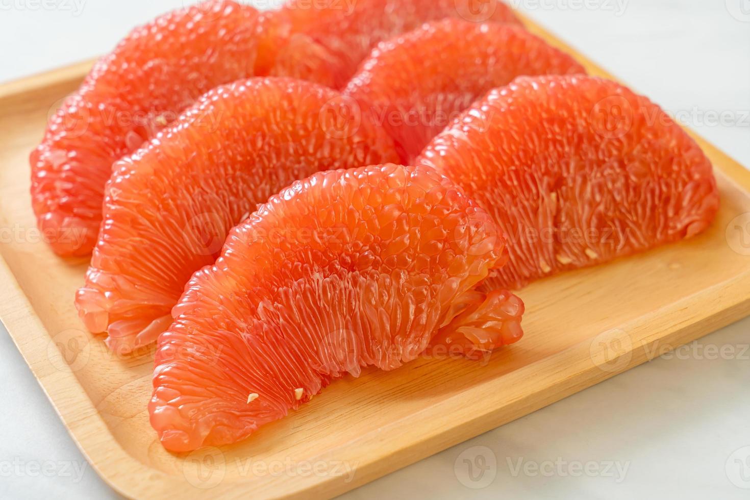 Pomelo rouge frais ou pamplemousse sur assiette photo