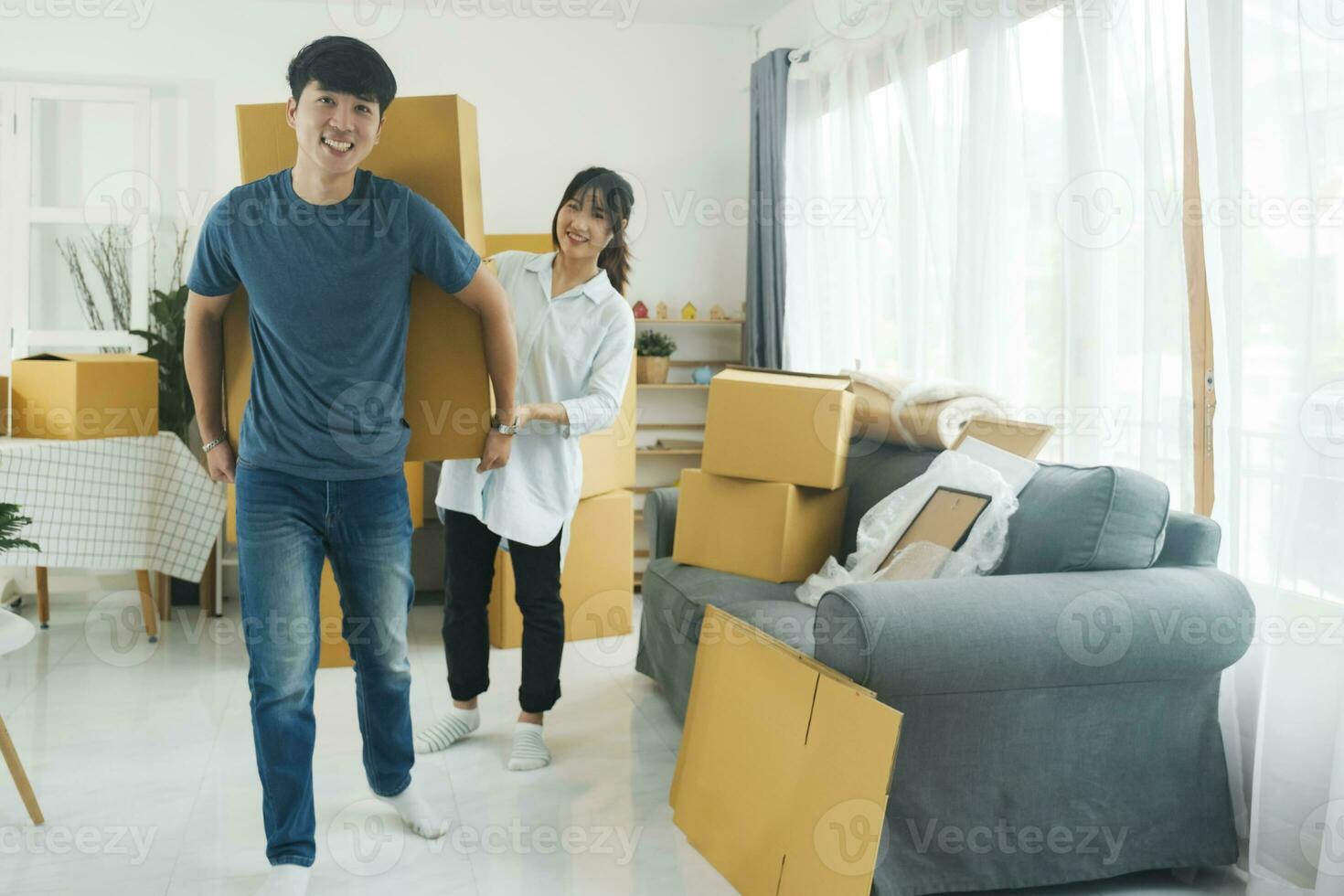 asiatique Jeune content Nouveau marié couple en mouvement à leur Nouveau maison ou réel domaine. photo