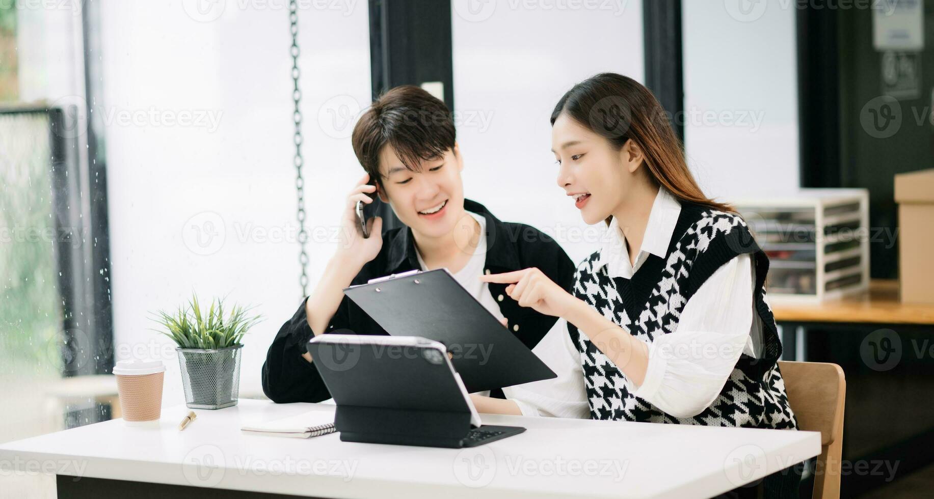 deux asiatique affaires ouvriers parlant sur le téléphone intelligent et en utilisant portable à le moderne bureau. photo