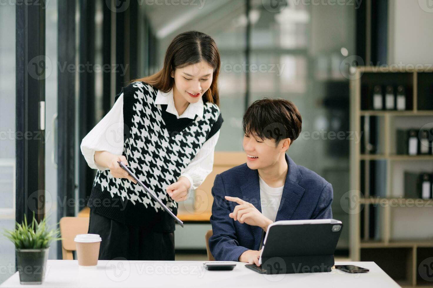 deux asiatique affaires ouvriers parlant sur le téléphone intelligent et en utilisant portable à le moderne bureau. photo