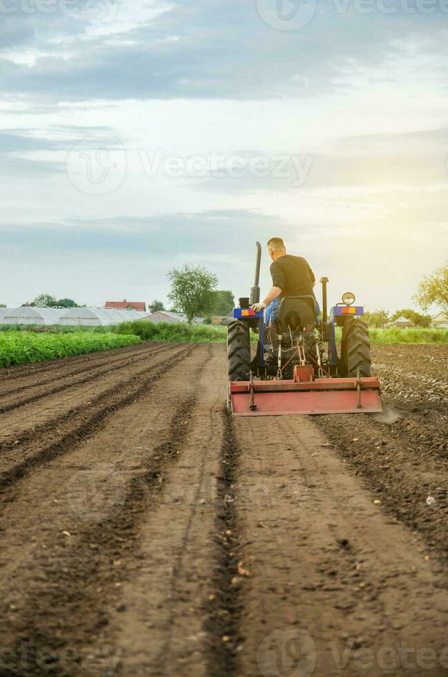 une agriculteur broie en haut solide sol à plante Nouveau cultures. développement de agricole économie, introduction de moderne les technologies. agriculture, agriculture. relâchement surface, terre cultivation. labour. photo