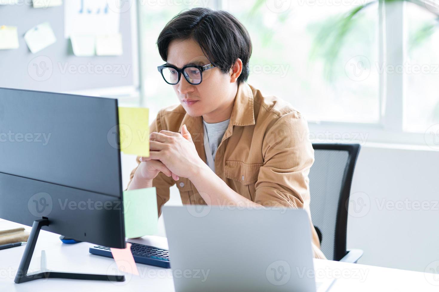 homme d'affaires asiatique travaillant avec un ordinateur au bureau photo