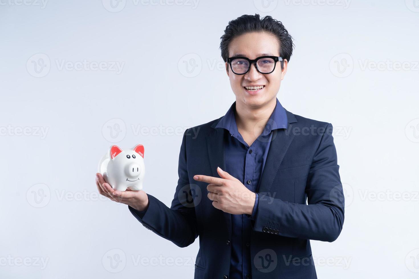 portrait d'un homme d'affaires asiatique tenant une tirelire photo
