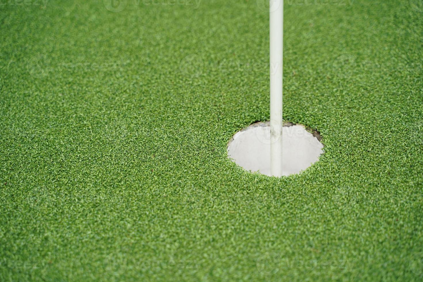 trou de golf et drapeau avec l'herbe verte, mise au point sélective. photo