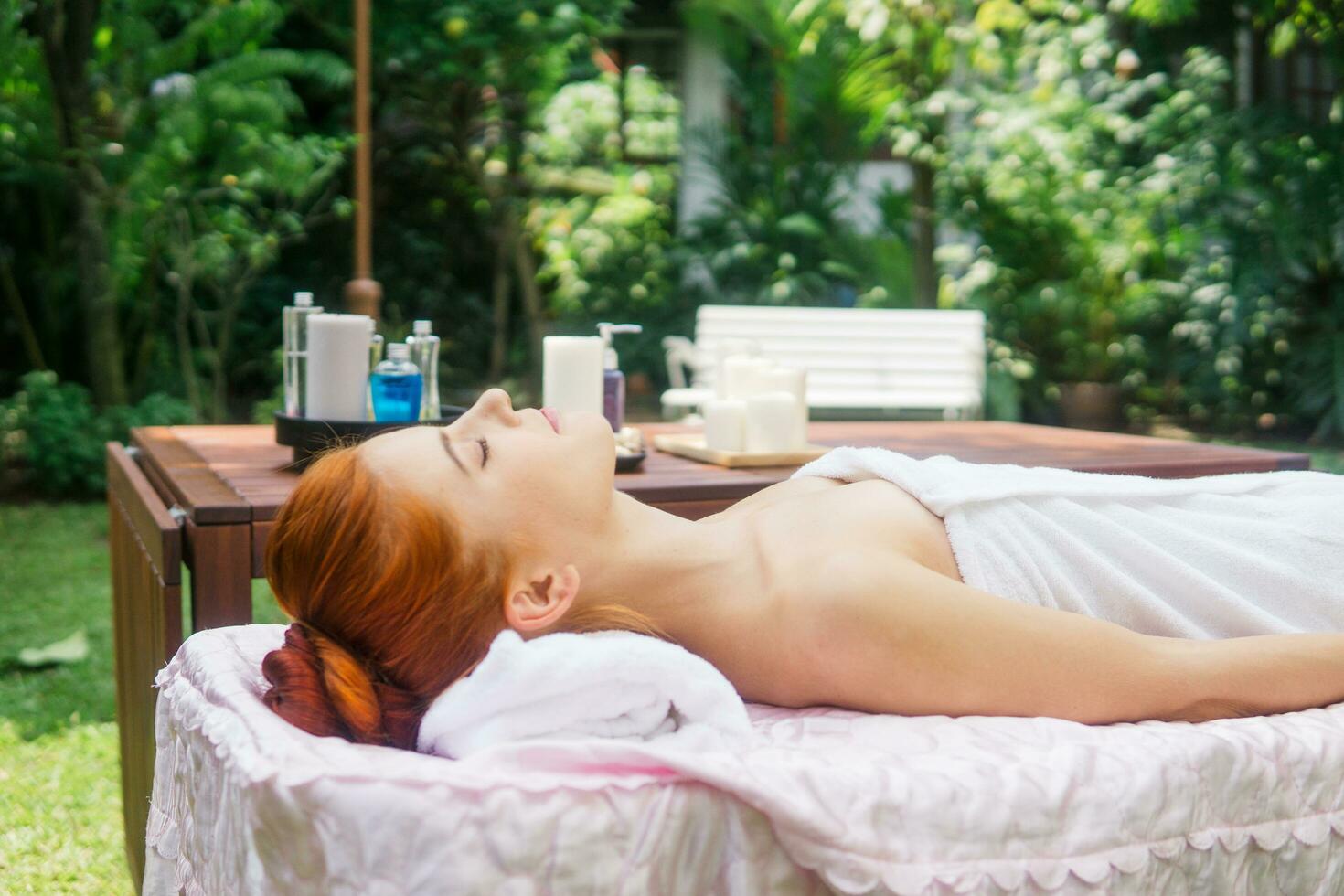 Jeune magnifique femme relaxant dans spa massage à l'extérieur dans tropical jardin. photo