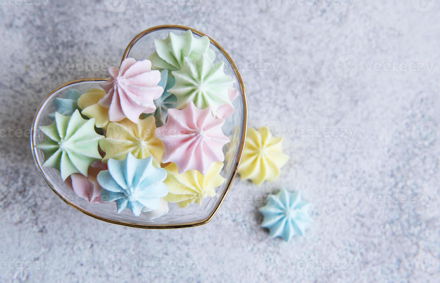 petites meringues colorées dans le bol en forme de coeur photo