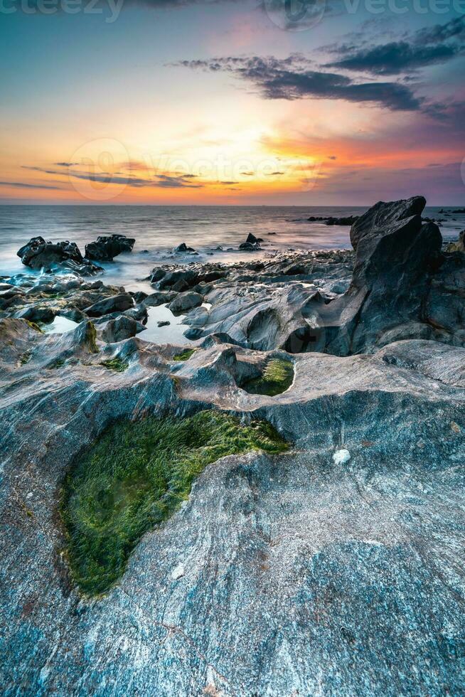 le coucher du soleil à le rocheux plage à vila nova de Gaïa, le Portugal. photo