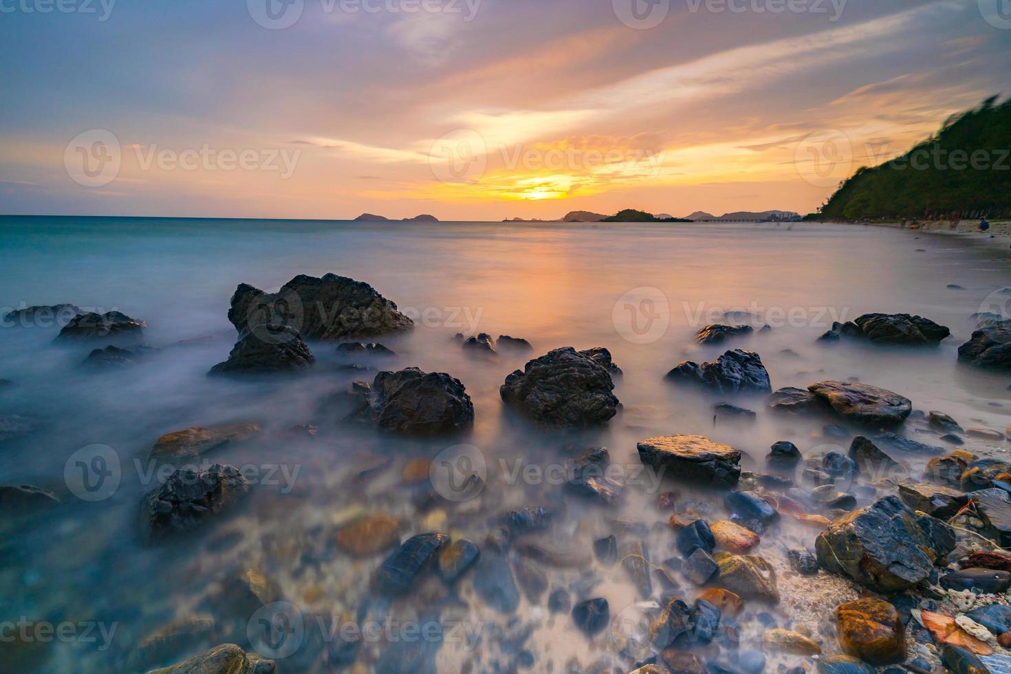 photo longue exposition de rochers sur la mer au coucher du soleil