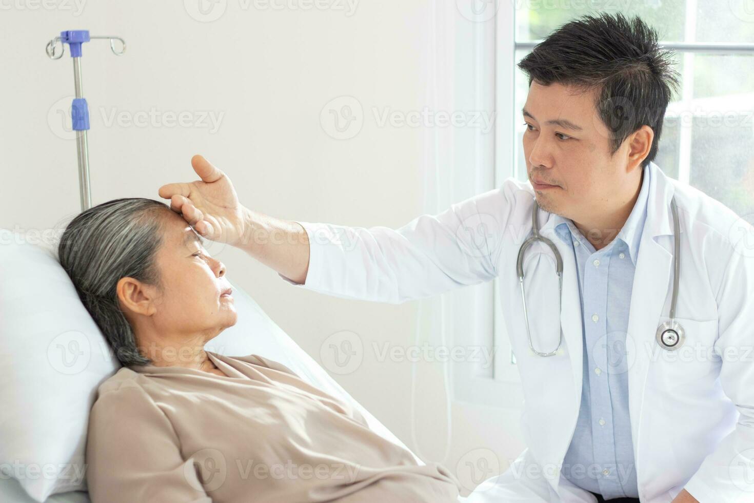 Masculin médecin discuter plus de médical record avec Sénior femme dans hôpital. photo