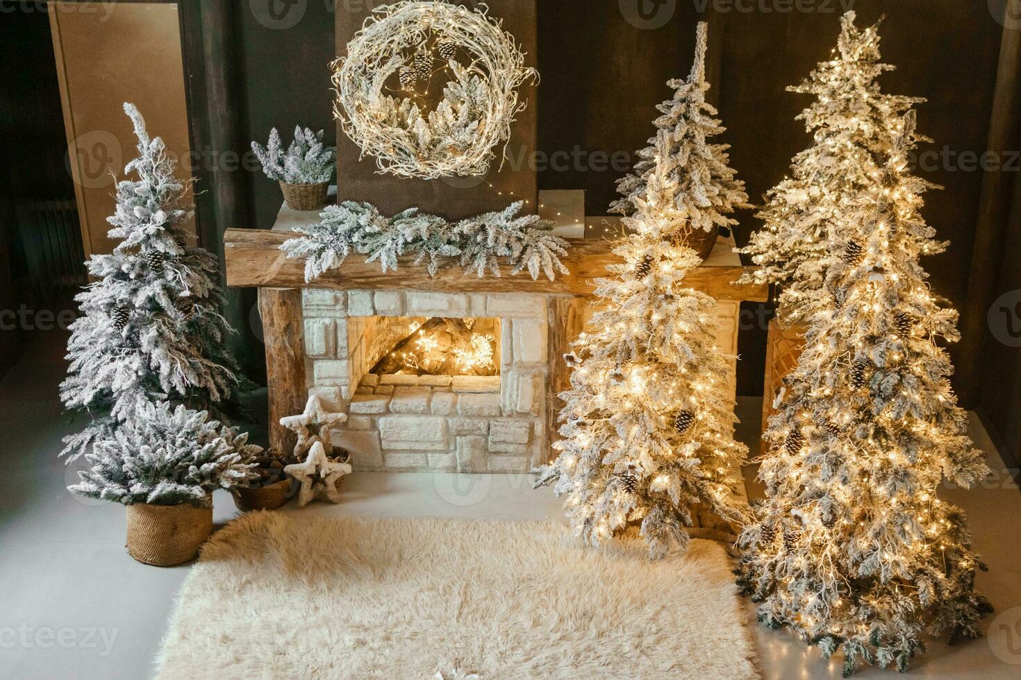 le intérieur de une pièce avec une cheminée, Noël des arbres avec artificiel neige et guirlandes, une couverture et une plateau avec chaud boissons. le magique atmosphère de Noël. photo
