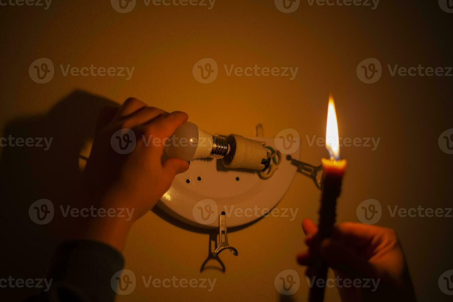 brûlant bougie près une commuté de lumière ampoule dans Achevée obscurité. coupure électrique, électricité désactivé, énergie crise ou Puissance panne, concept image photo
