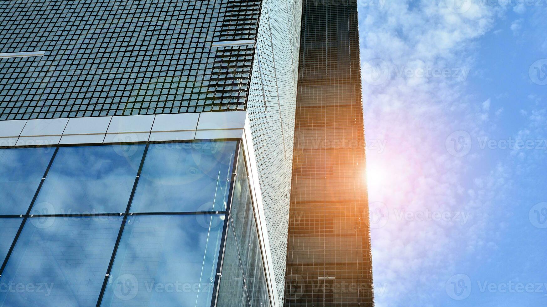 abstrait fragment de contemporain architecture, des murs fabriqué de verre et béton. abstrait fermer de le revêtu de verre façade de une moderne bâtiment couvert dans réfléchissant assiette verre. photo