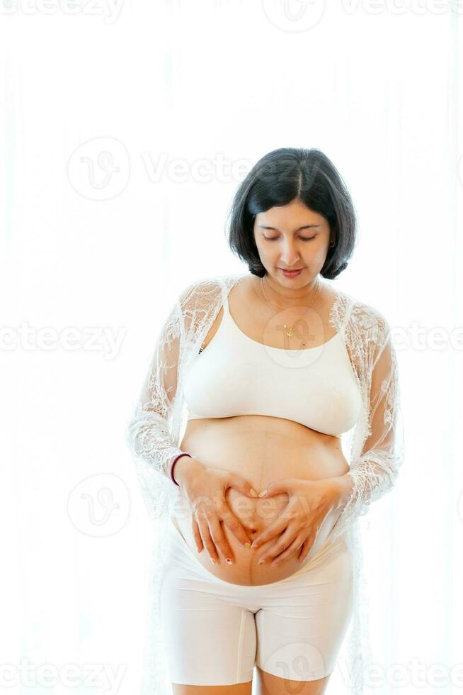 portrait de une Enceinte femme émouvant sa gros ventre proche en haut, mère, grossesse, gens et attente. femme en portant gros Enceinte estomac photo