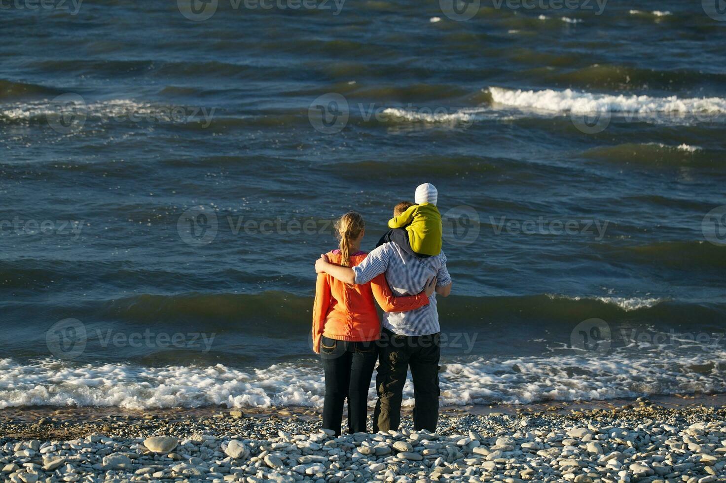 Jeune famille profiter une journée à le bord de mer photo