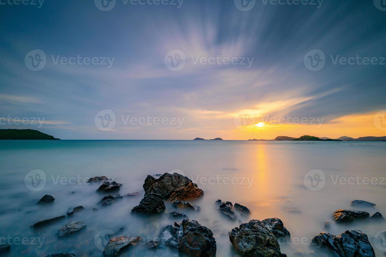 photo longue exposition du coucher de soleil sur la mer avec des nuages qui passent
