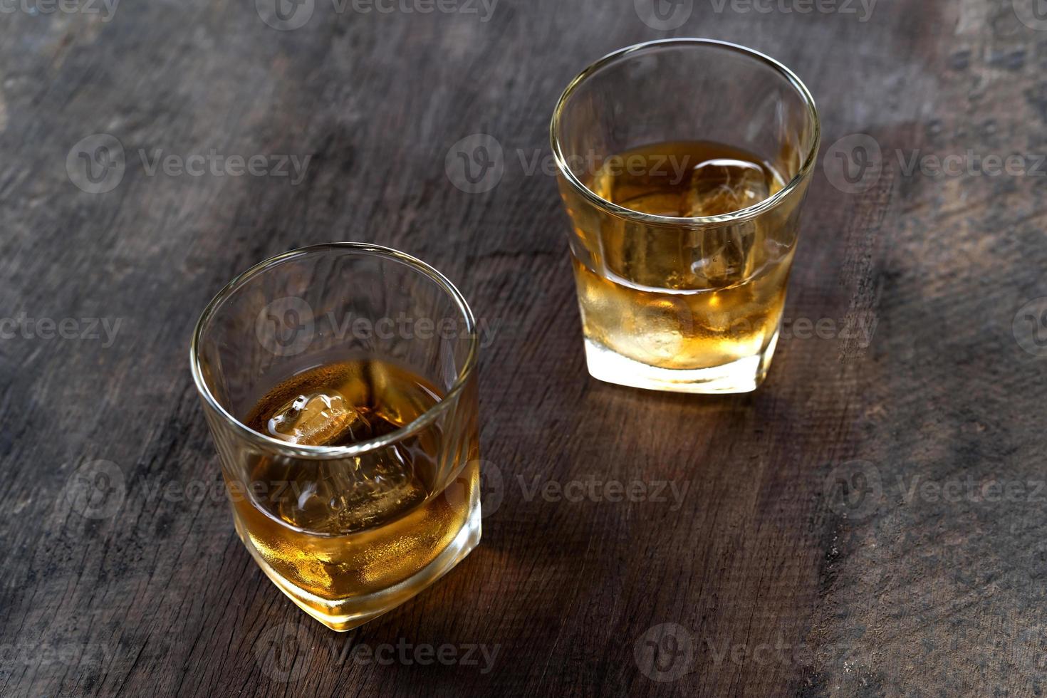 vue de dessus du whisky avec de la glace en verre sur une table en bois photo