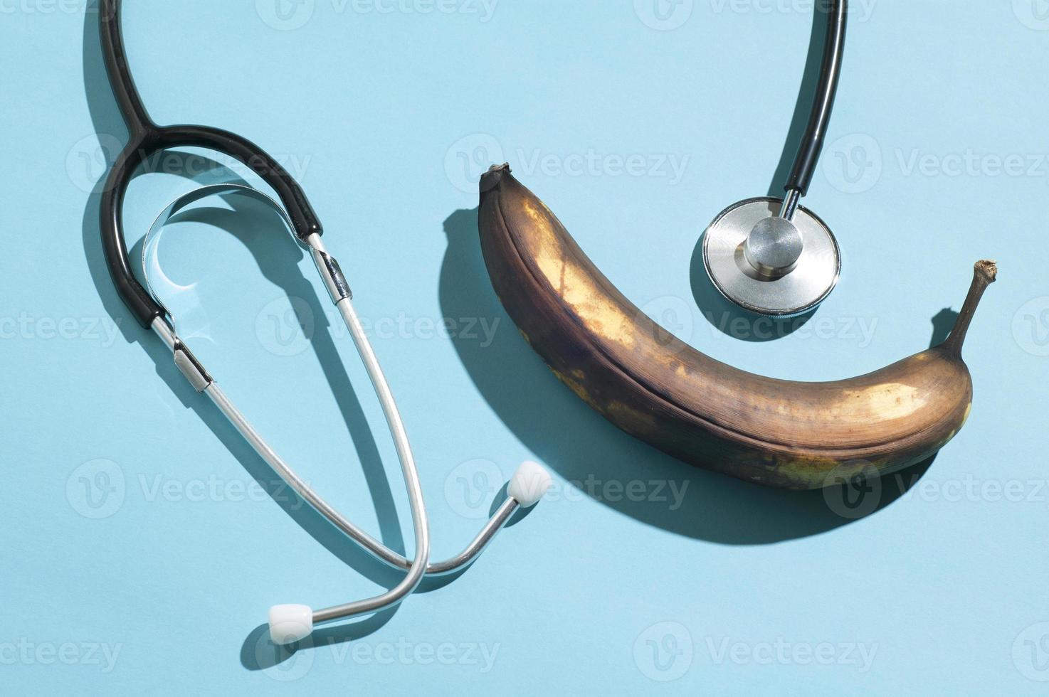 disposition minimale avec une banane pourrie et un stéthoscope traditionnel avec des ombres dures photo