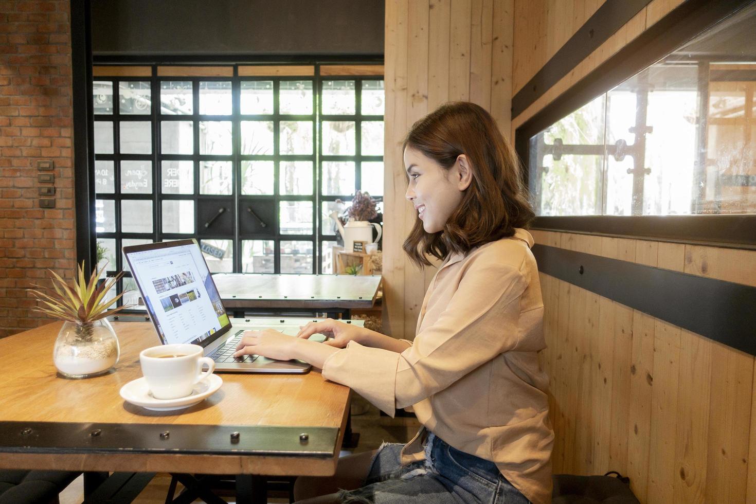 belle femme d'affaires travaille avec son ordinateur portable dans un café photo