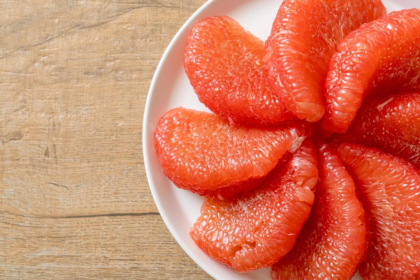 Pomelo rouge frais ou pamplemousse sur assiette photo