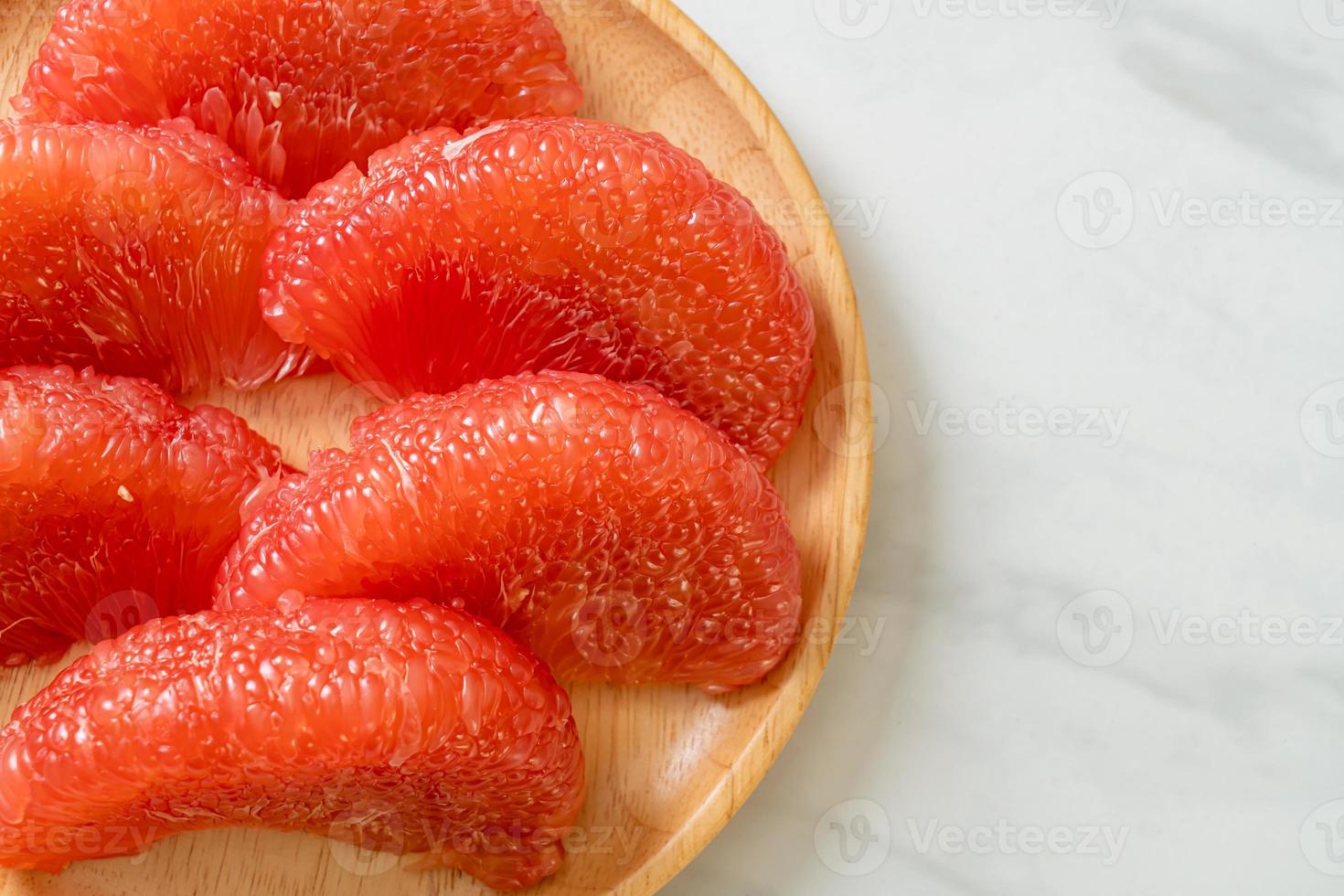 Pomelo rouge frais ou pamplemousse sur assiette photo