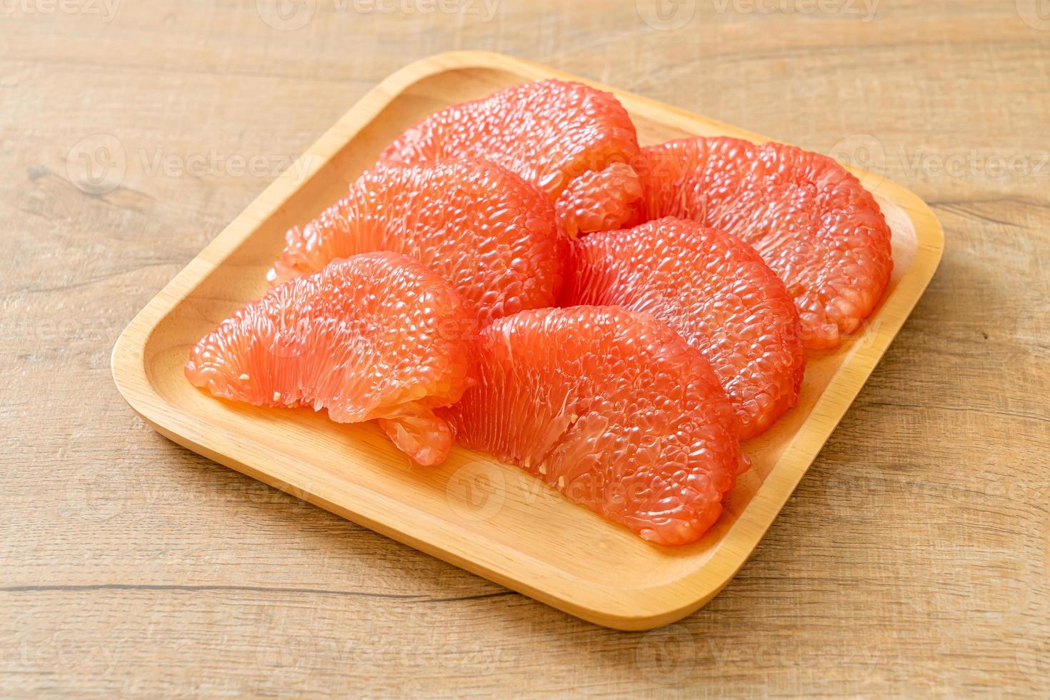 Pomelo rouge frais ou pamplemousse sur assiette photo