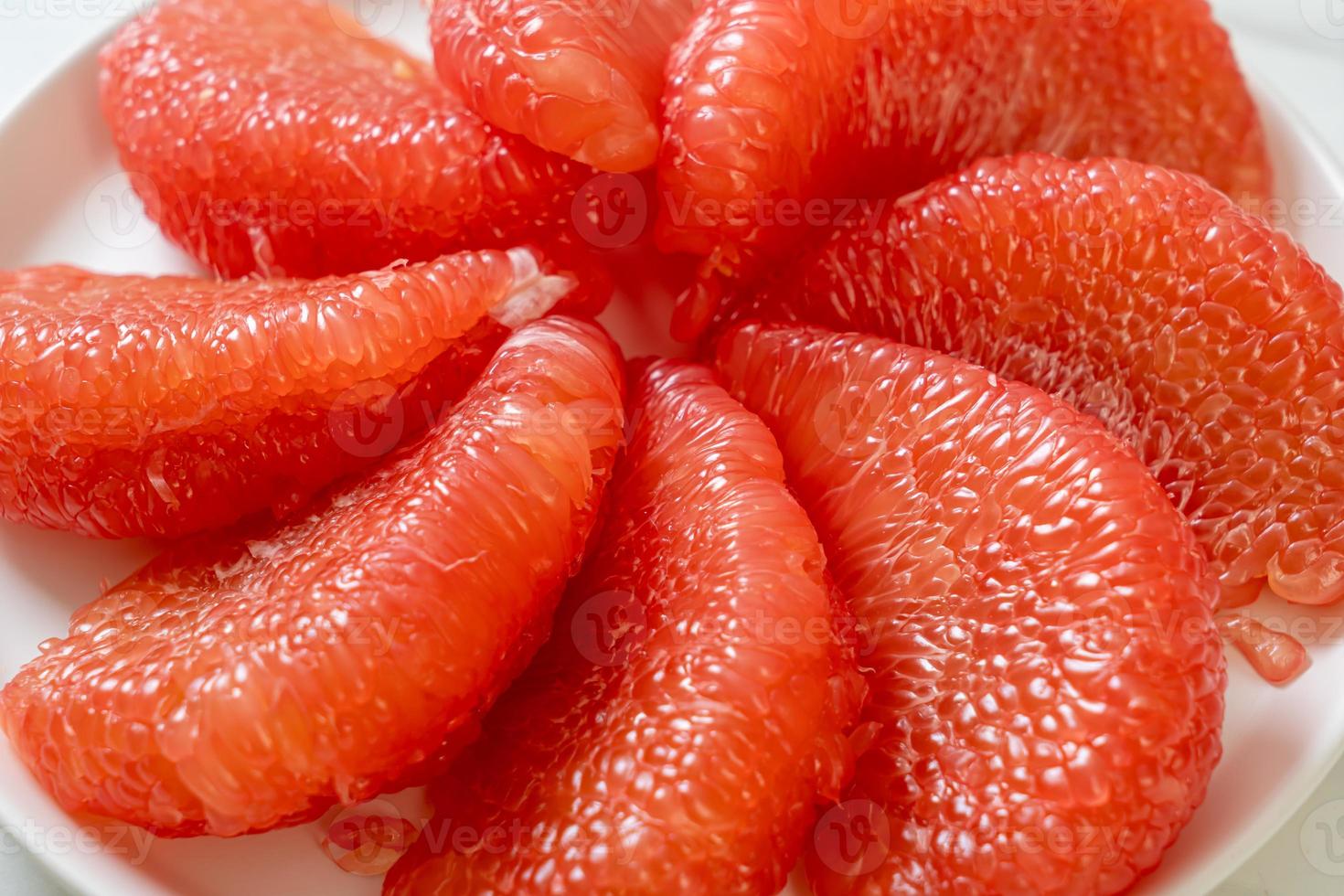 Pomelo rouge frais ou pamplemousse sur assiette photo