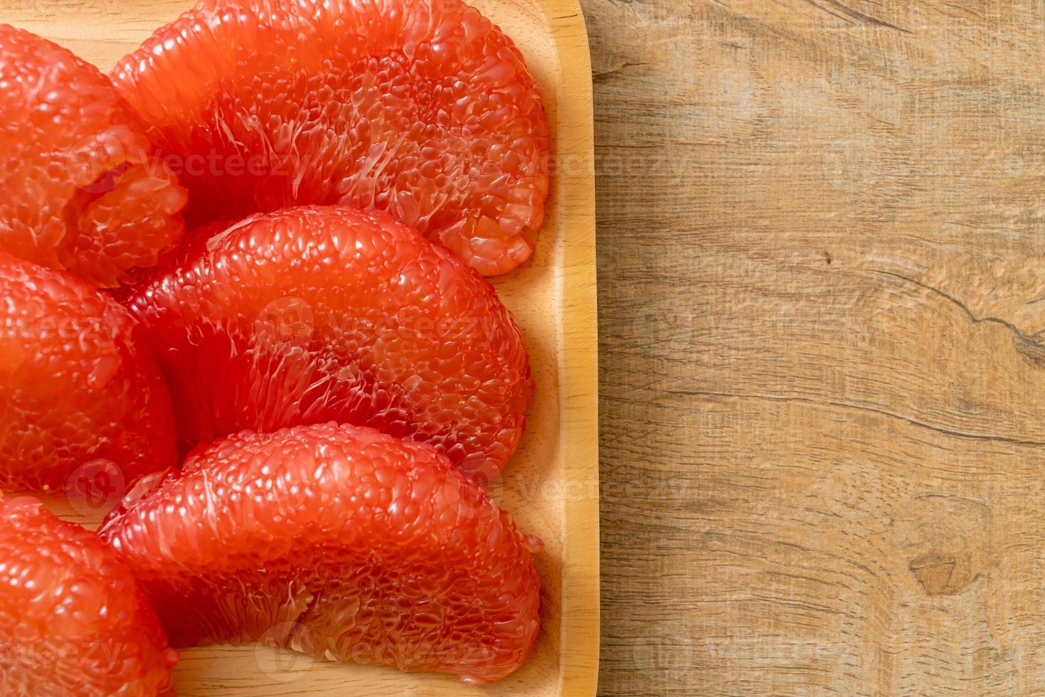 Pomelo rouge frais ou pamplemousse sur assiette photo