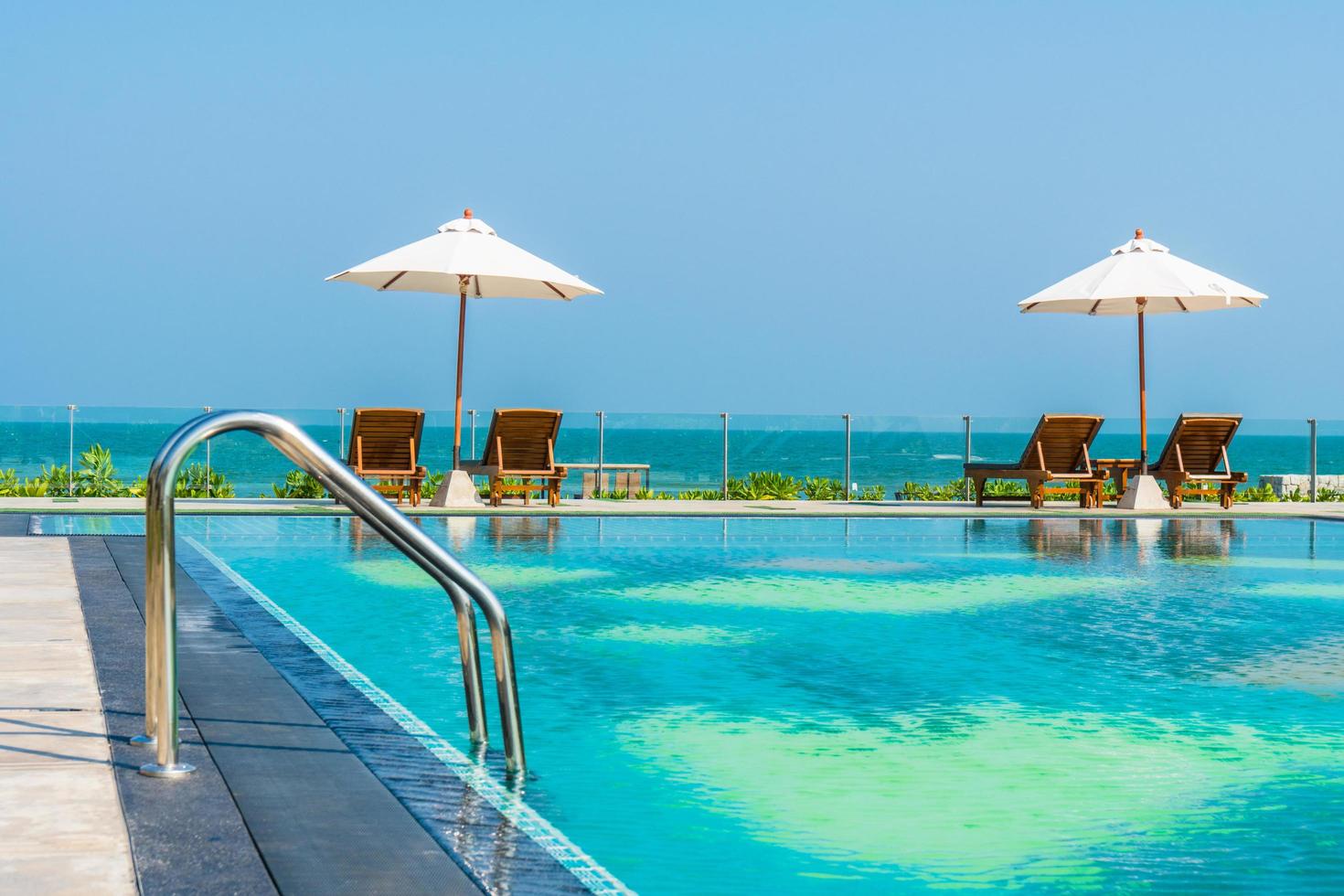 beau parasol et chaise autour de la piscine de l'hôtel et du complexe photo