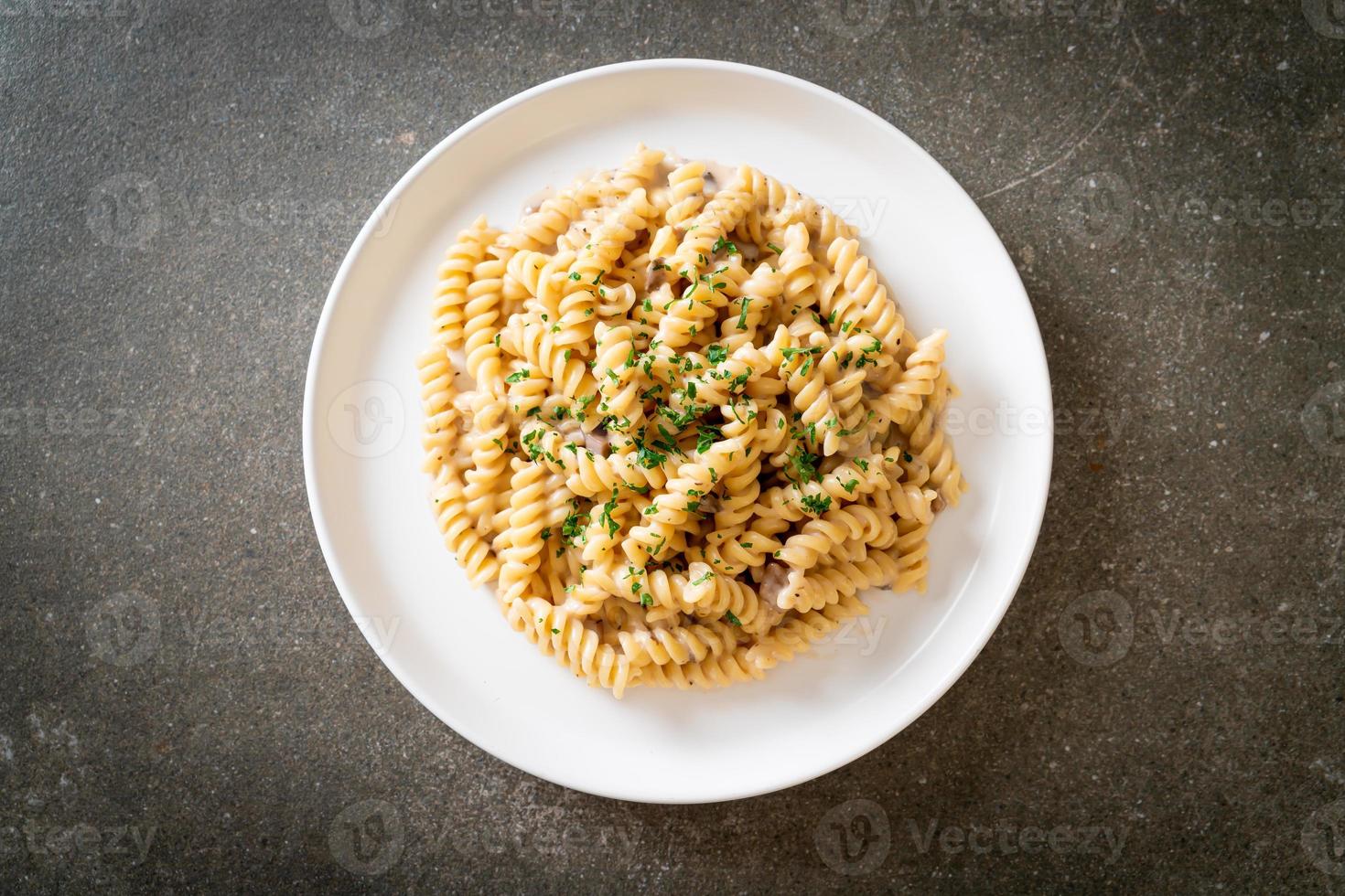 spirali ou sauce à la crème de champignons de pâtes en spirale avec du persil - style de cuisine italienne photo