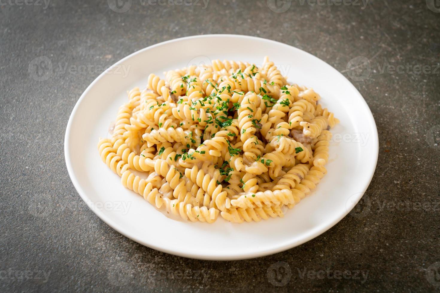 spirali ou sauce à la crème de champignons de pâtes en spirale avec du persil - style de cuisine italienne photo