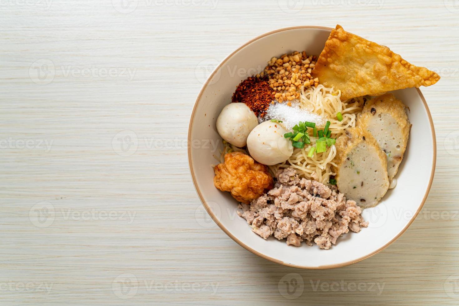 nouilles aux œufs épicées avec boulettes de poisson et boulettes de crevettes sans soupe - style cuisine asiatique photo