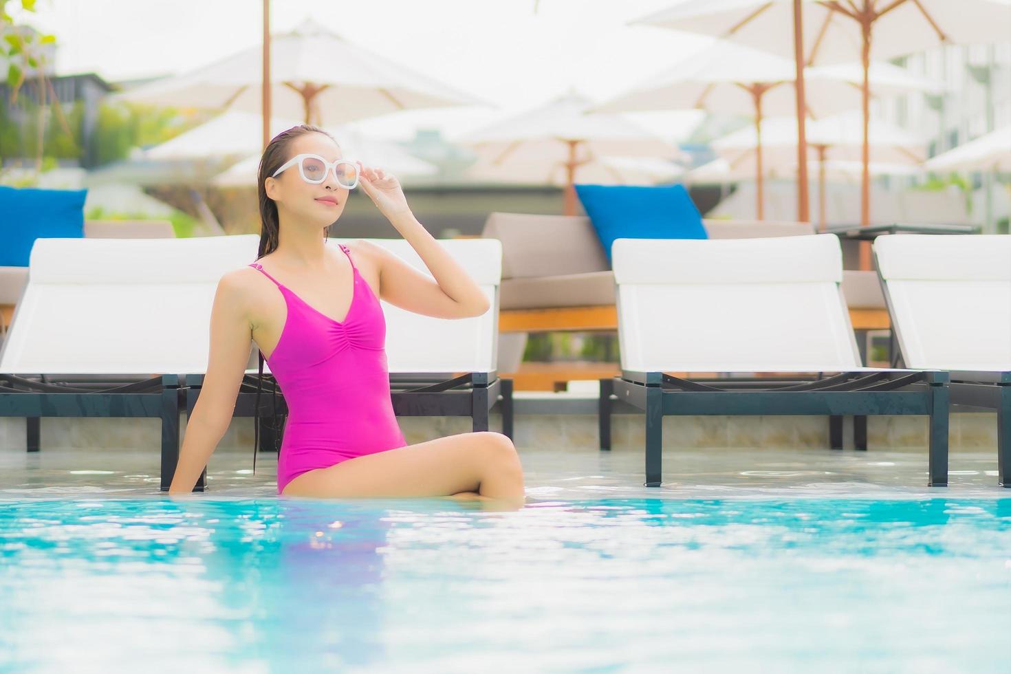 Portrait belle jeune femme asiatique se détendre sourire autour de la piscine extérieure de l'hôtel resort photo