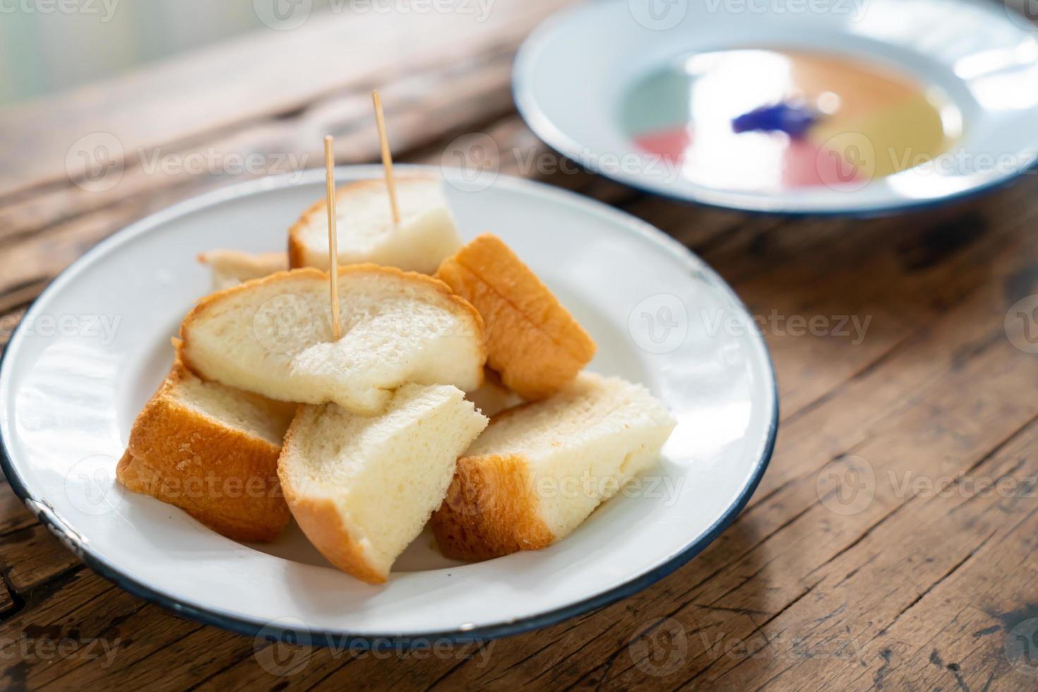 pain grillé cuit à la vapeur avec crème pâtissière colorée sur fond de bois photo