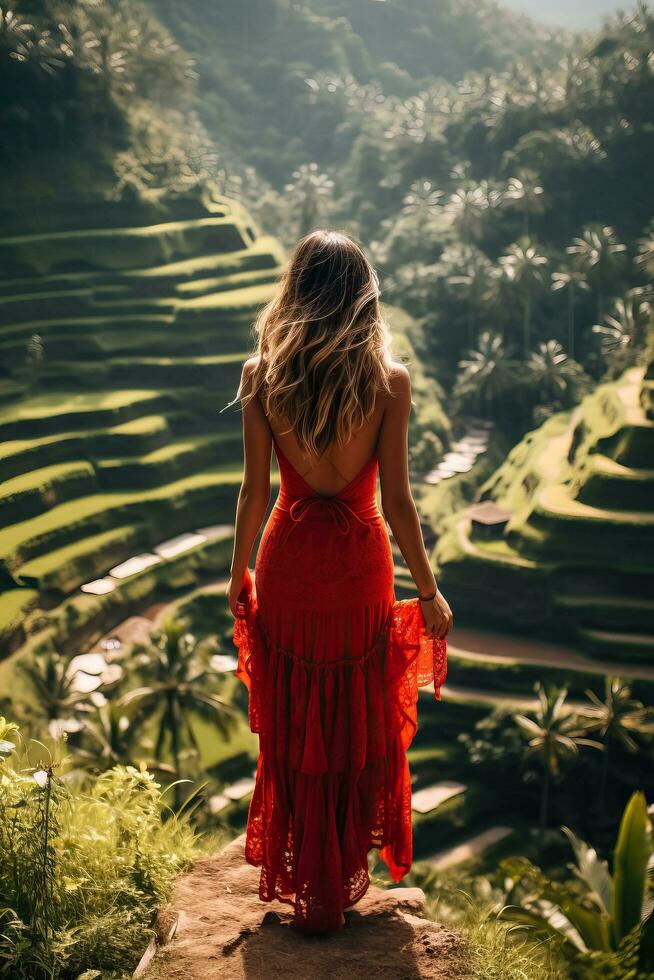 une Jeune femelle touristique dans une rouge robe admiratif le Stupéfiant tegalalang riz terrasse dans bali Indonésie photo