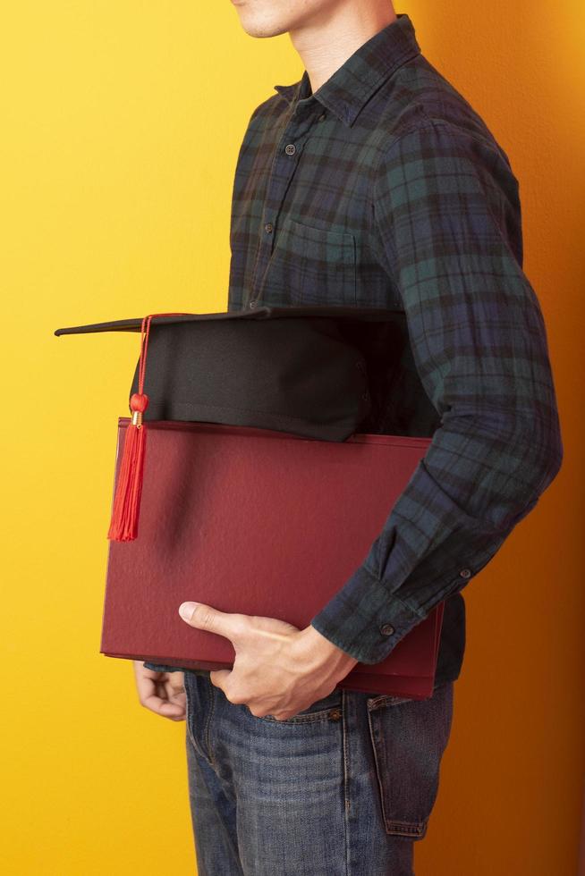 l'homme de l'université est heureux avec l'obtention du diplôme sur fond jaune photo