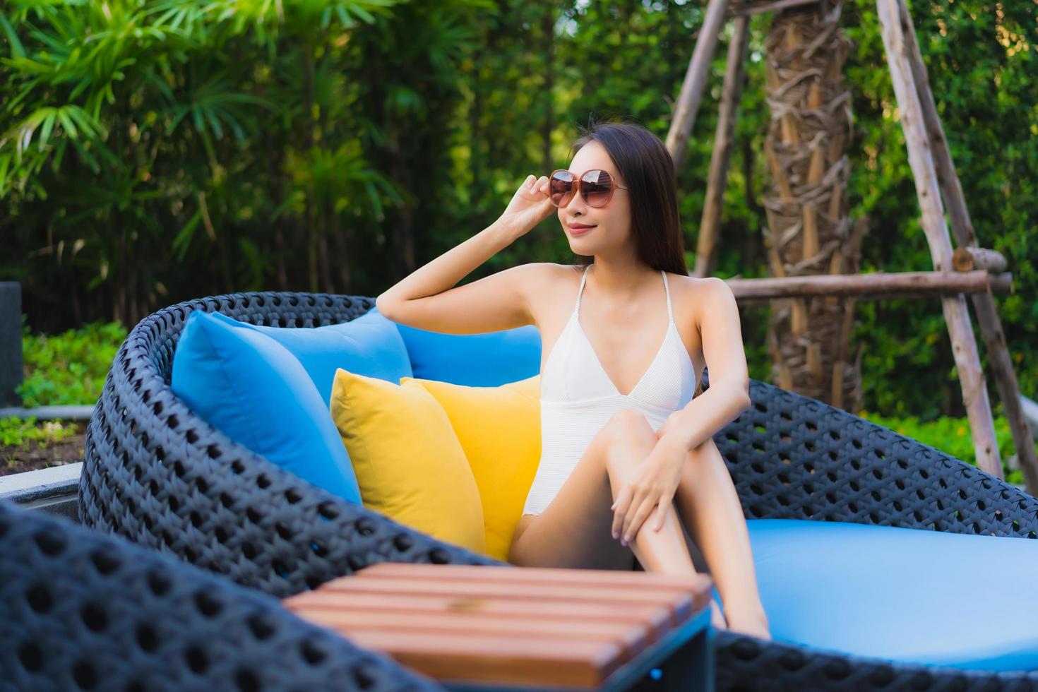 Portrait de belles jeunes femmes asiatiques sourire heureux se détendre autour d'une piscine extérieure photo