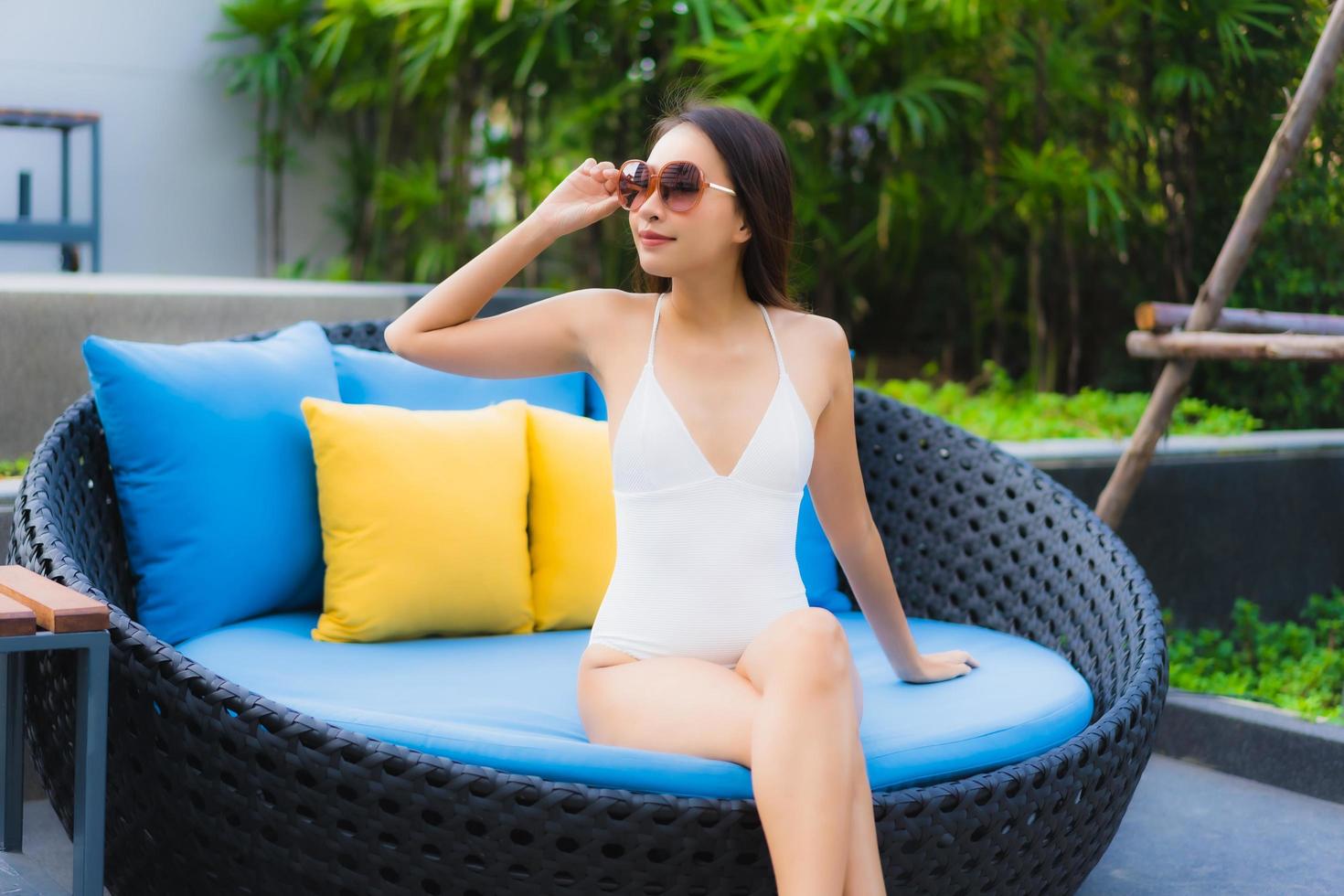 Portrait de belles jeunes femmes asiatiques sourire heureux se détendre autour d'une piscine extérieure photo