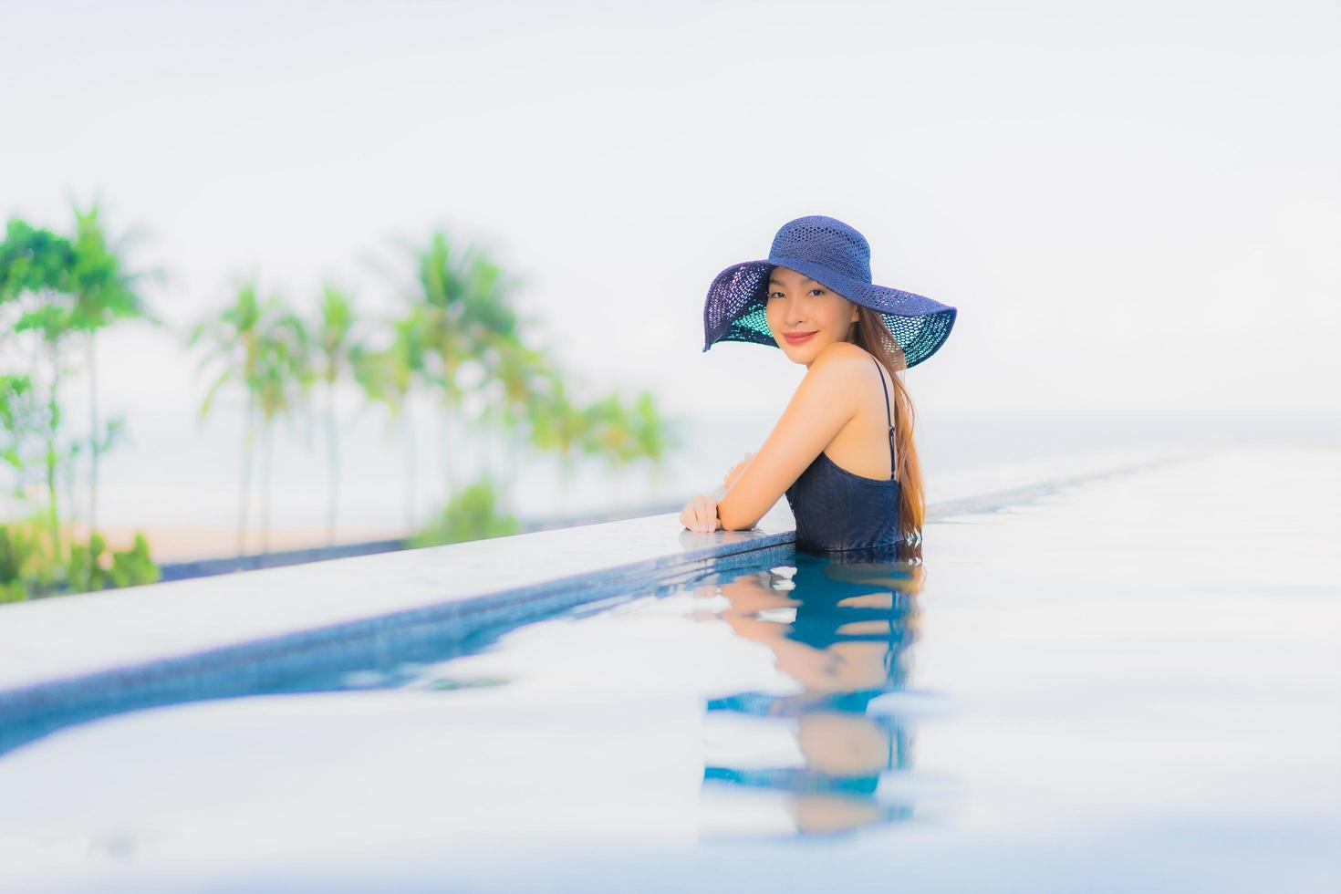 Portrait de belles jeunes femmes asiatiques sourire heureux se détendre piscine extérieure à l'hôtel photo