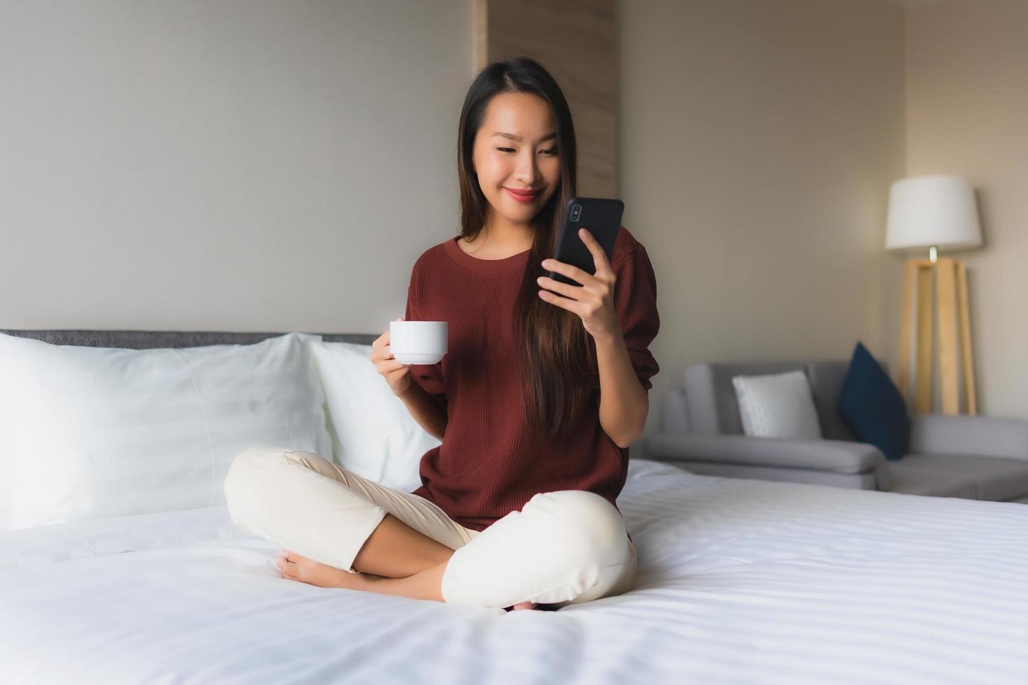 Portrait de belles jeunes femmes asiatiques sourire heureux avec café et téléphone portable photo