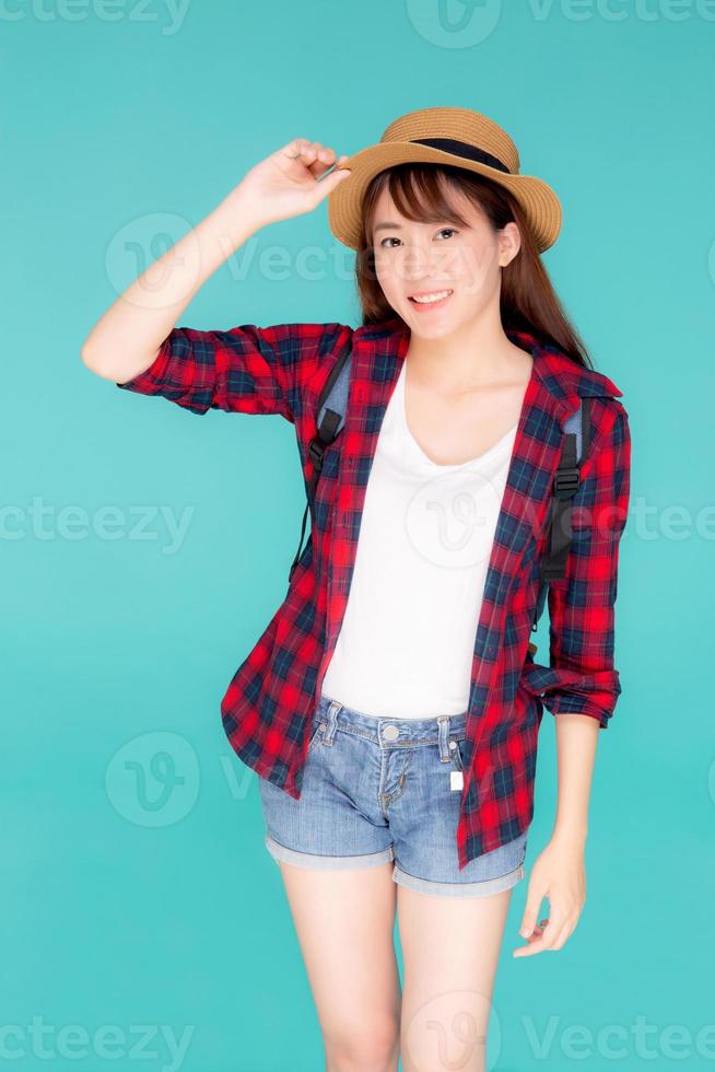 beau portrait jeune femme asiatique tenant un chapeau sourire expression joyeuse et profiter des vacances de voyage d'été en vacances fond bleu isolé, touriste heureuse fille d'asie confiante et excitée. photo