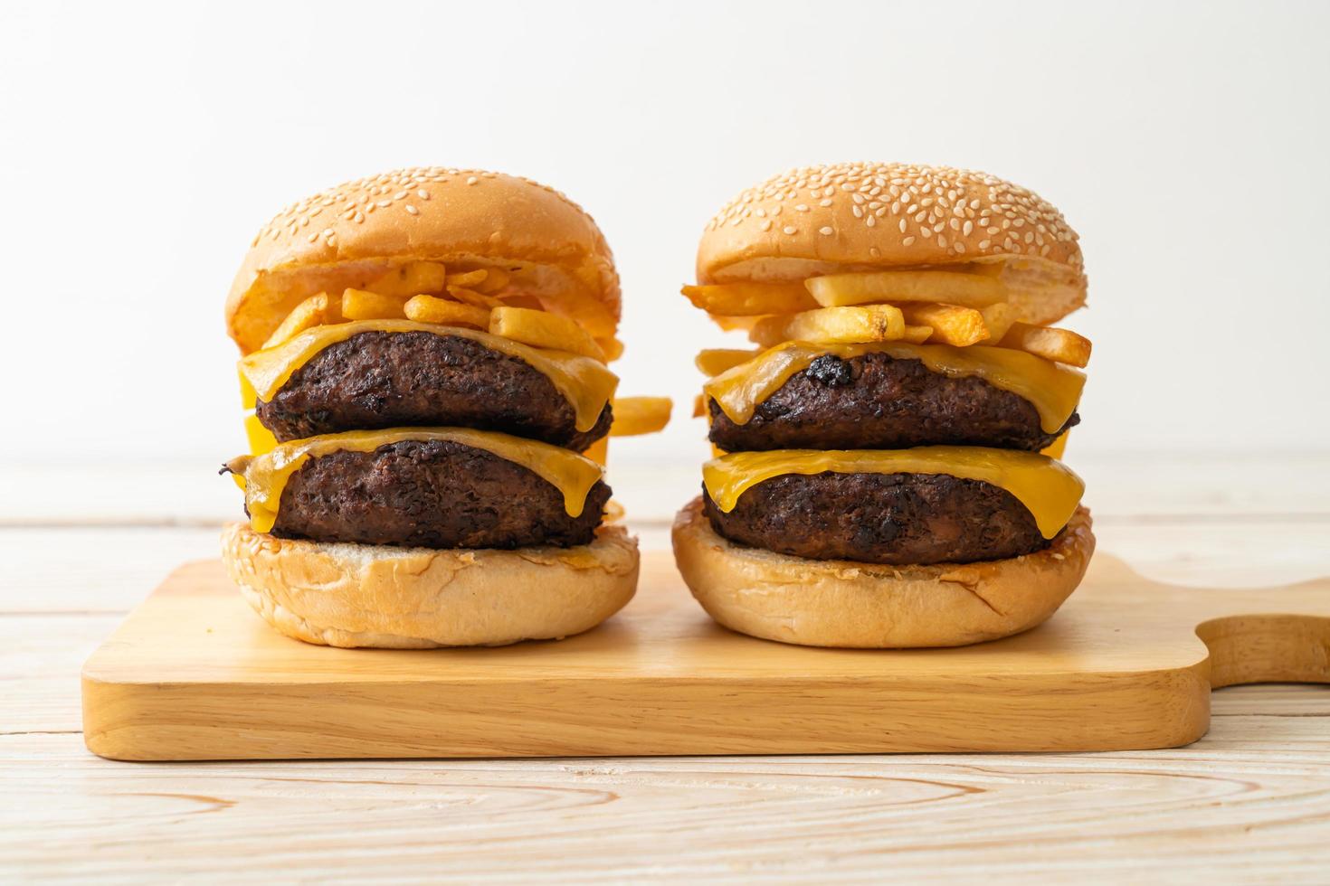 hamburgers ou hamburgers de boeuf avec du fromage et des frites - style de nourriture malsaine photo