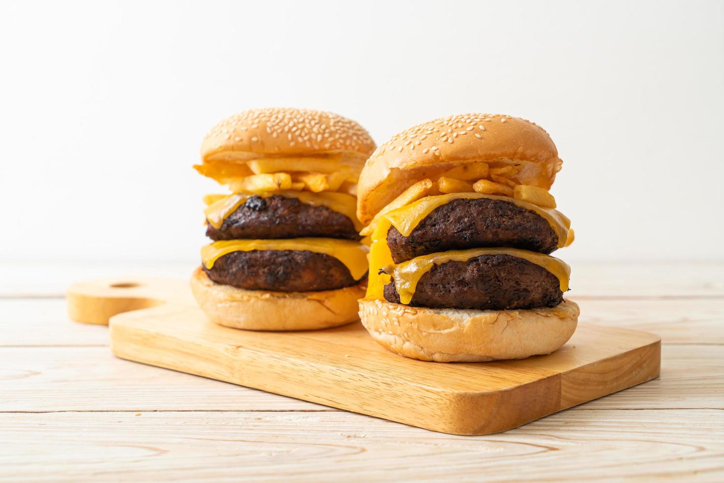 hamburgers ou hamburgers de boeuf avec du fromage et des frites - style de nourriture malsaine photo