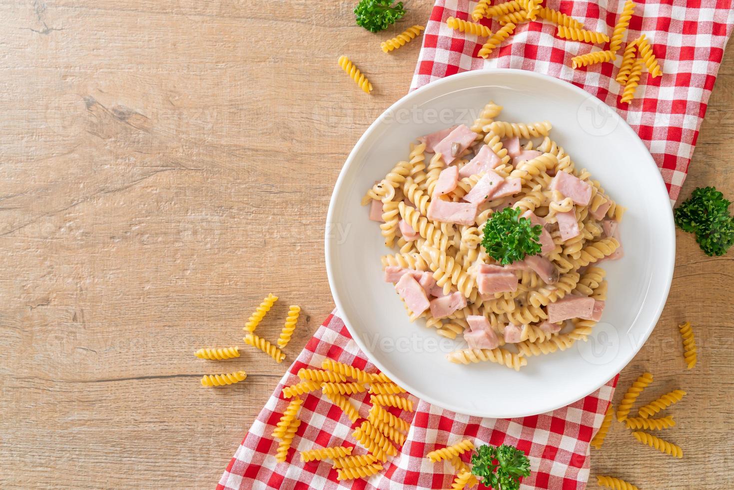 spirali ou sauce à la crème de champignons de pâtes en spirale avec du jambon - style de cuisine italienne photo