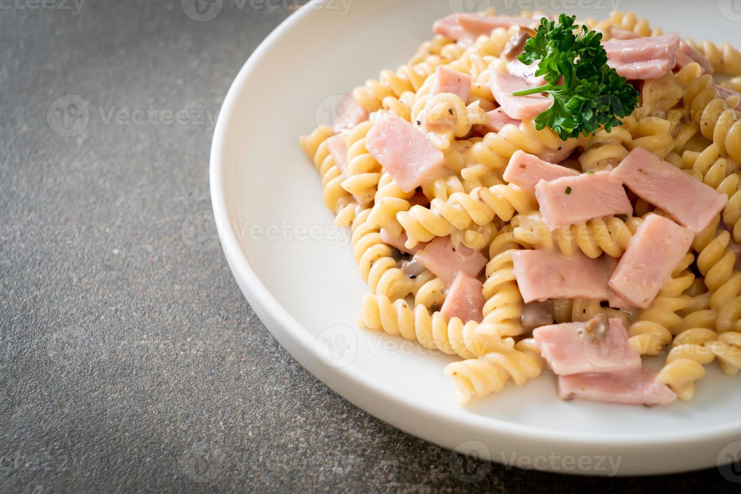 spirali ou sauce à la crème de champignons de pâtes en spirale avec du jambon - style de cuisine italienne photo