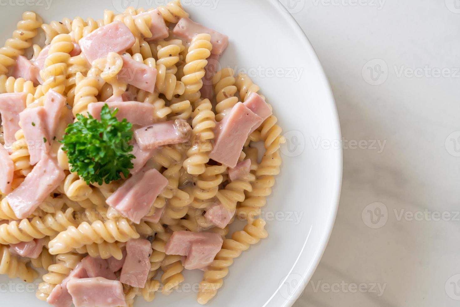 spirali ou sauce à la crème de champignons de pâtes en spirale avec du jambon - style de cuisine italienne photo