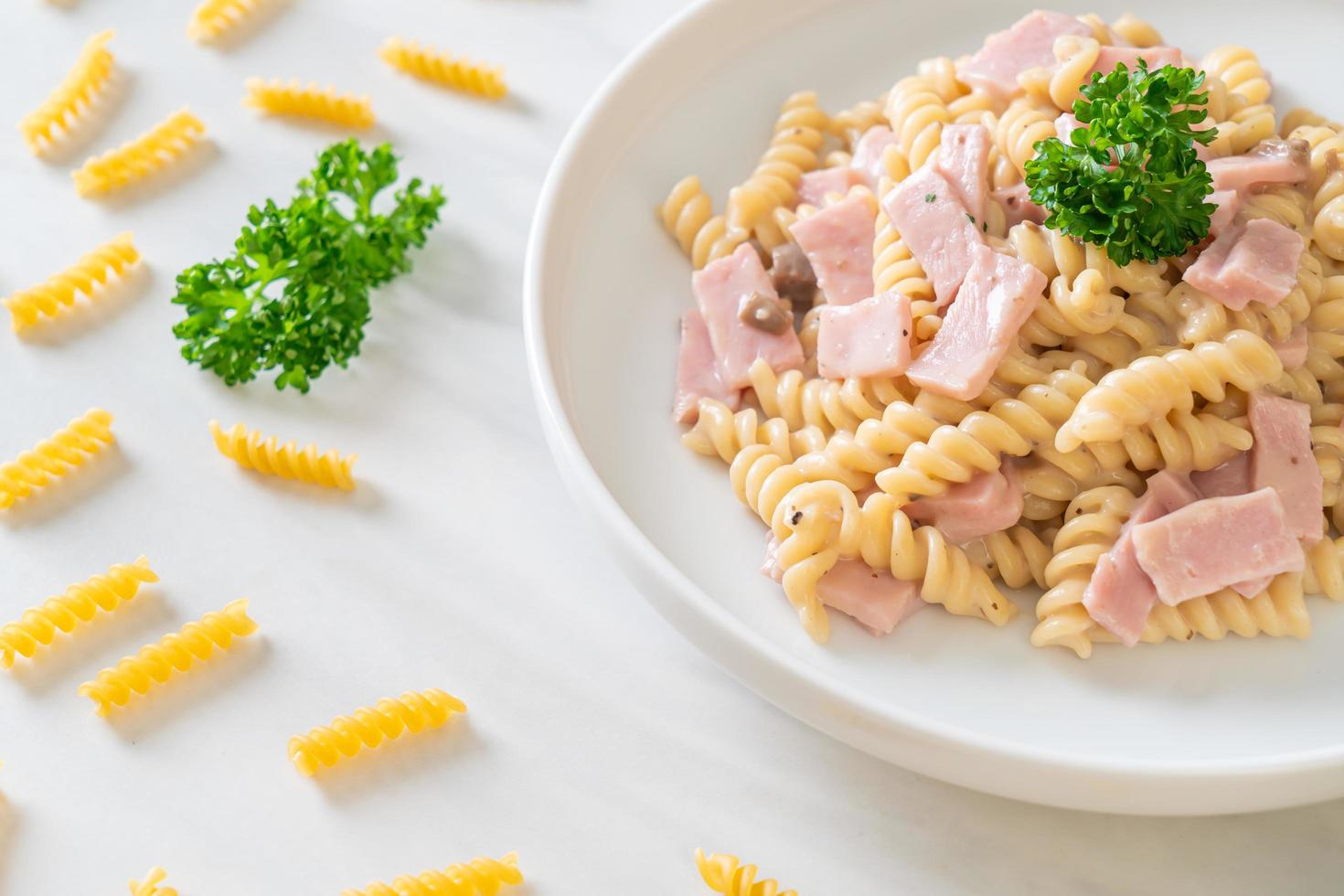 spirali ou sauce à la crème de champignons de pâtes en spirale avec du jambon - style de cuisine italienne photo