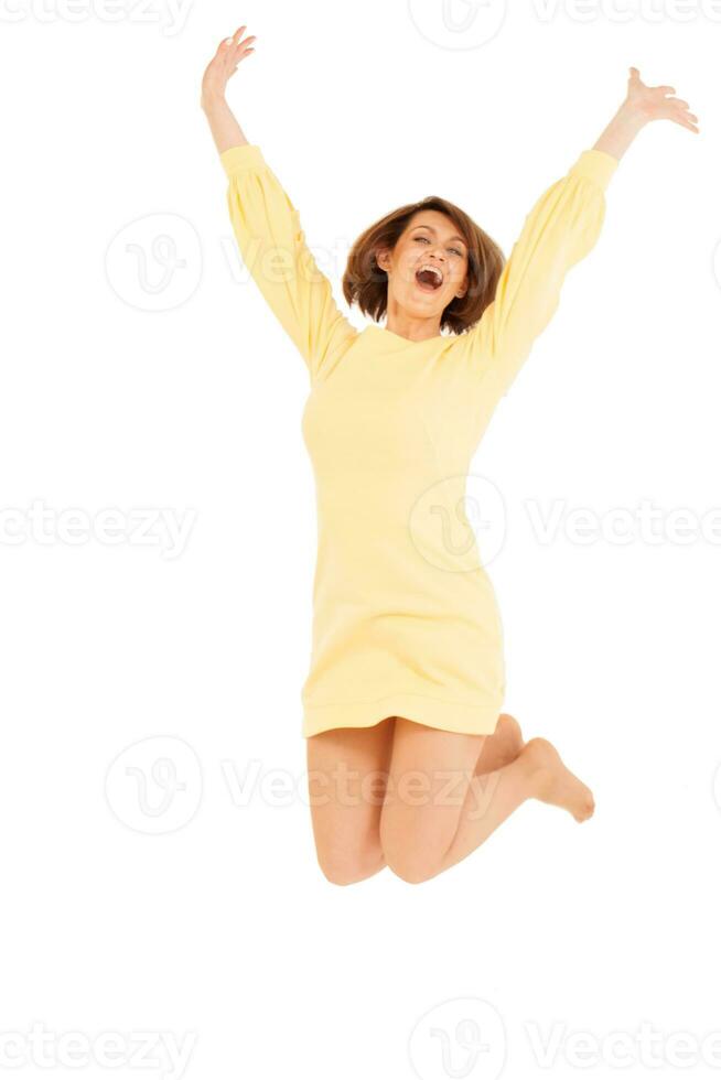 souriant adulte femme sauter avec mains en haut photo