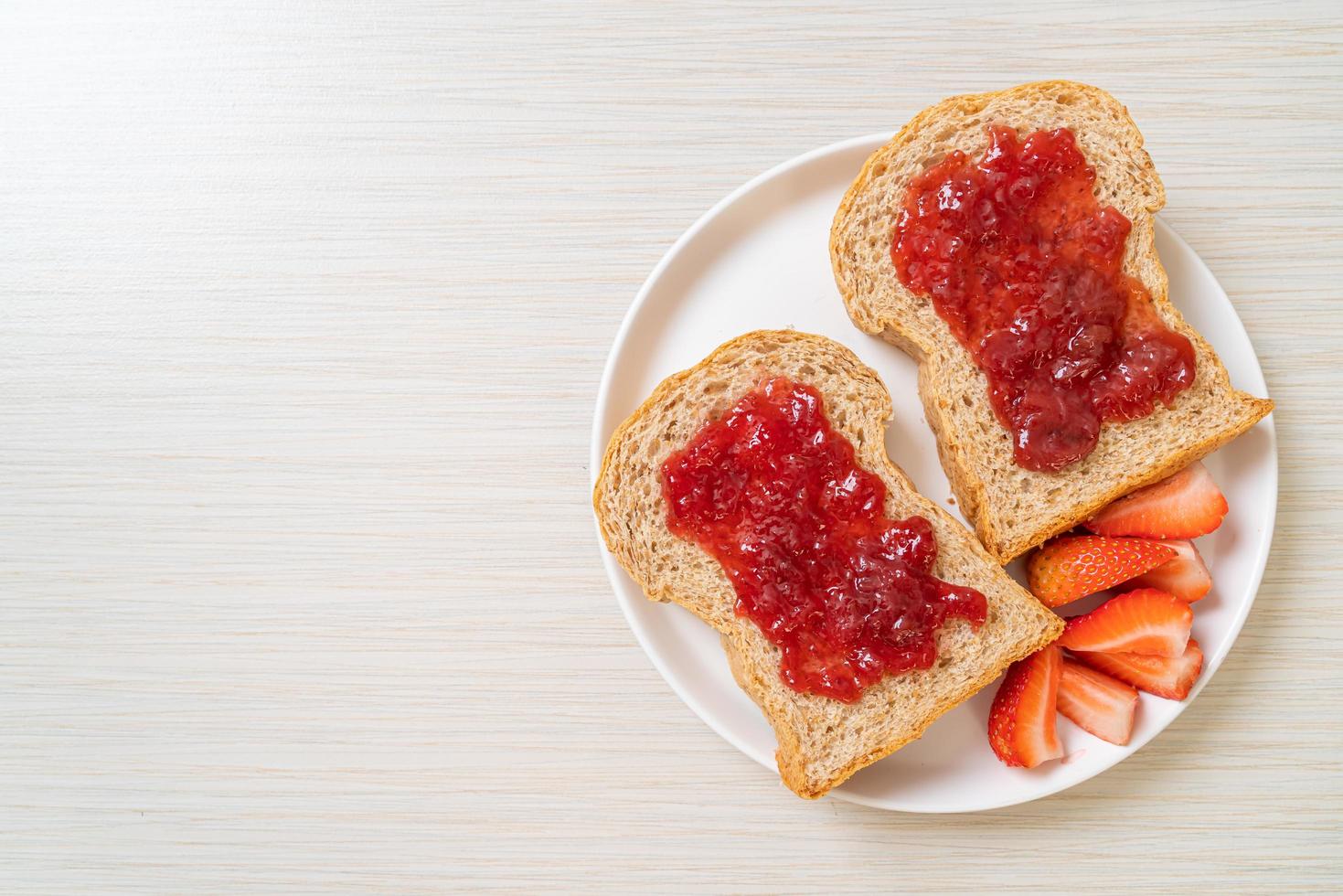 pain de blé entier fait maison avec confiture de fraise et fraise fraîche photo