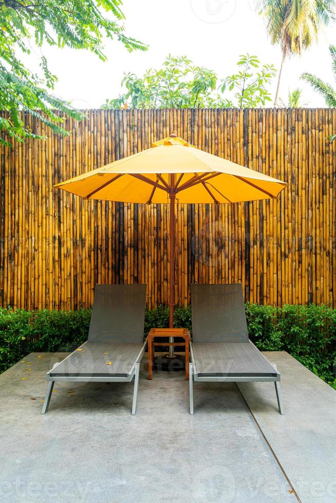 Parapluie et décoration de lit de piscine autour de la piscine de l'hôtel photo