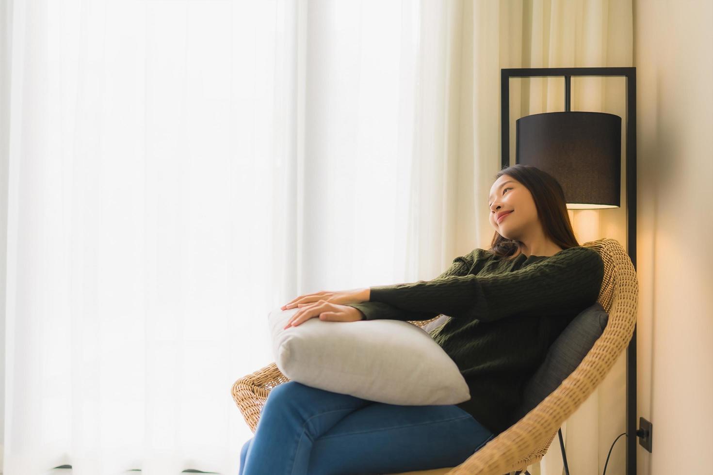 Portrait de belles jeunes femmes asiatiques sourire heureux se détendre assis sur une chaise canapé photo